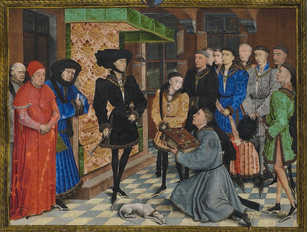 Rogier van der Weyden miniature 1447–48. Philip dresses his best, in an extravagant chaperon, to be presented with a History of Hainault by the author, Jean Wauquelin, flanked by his son Charles and his chancellor Nicolas Rolin.